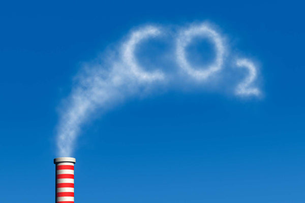 CO2 spelt out in a chimney's smoke exhaust.  Carbon Dioxide reduction is what is necessary for decarbonisation.