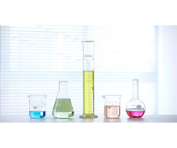 Lab table with 5 beakers of different chemicals symbolising petrochemicals used in petrochemical products.