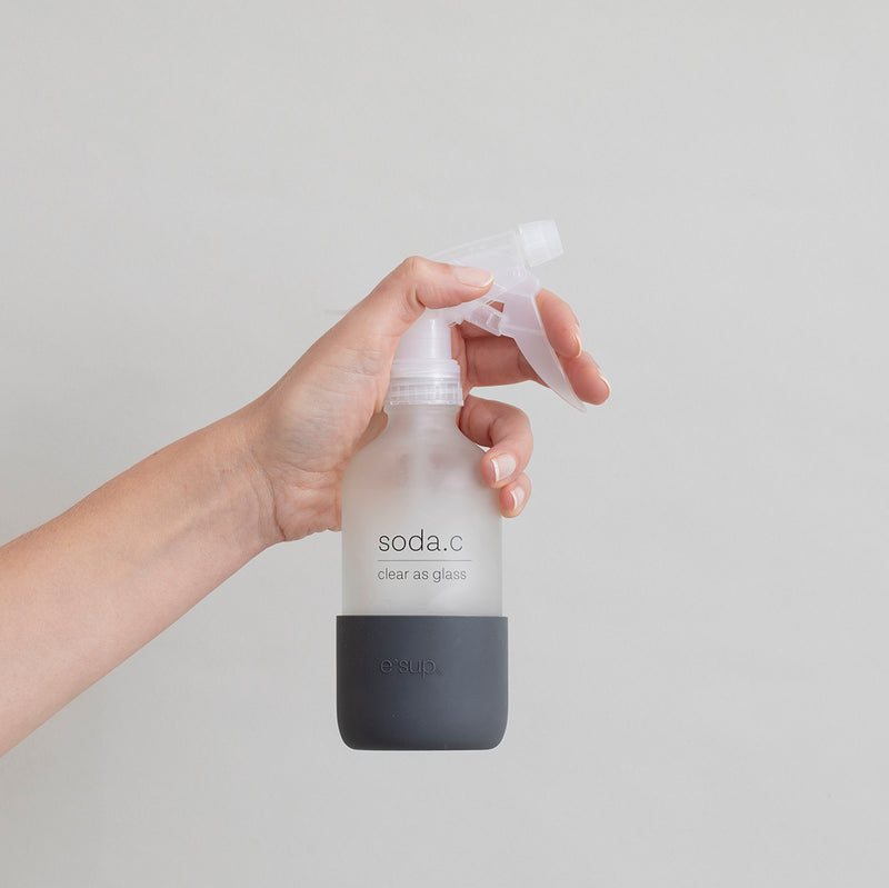 soda.c reusable glass bottle held up by a hand