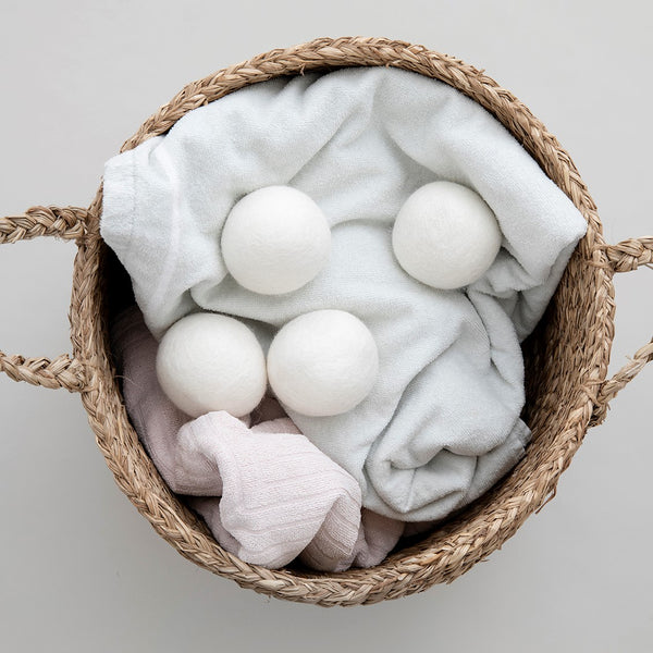 wool dryer balls in basket with towels